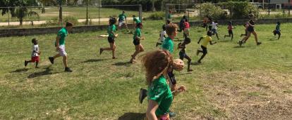 Local school children participate in a Physical Education class run by volunteers in Belize. A group of volunteers in Belize run a sports coaching class at a local school.